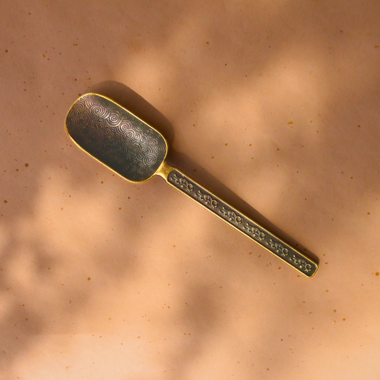 Antique-look tea scoop to compliment your tea-time collection. A textured tea scoop with a capacity of 2 teaspoons. Brass in colour with spiral embellishments.